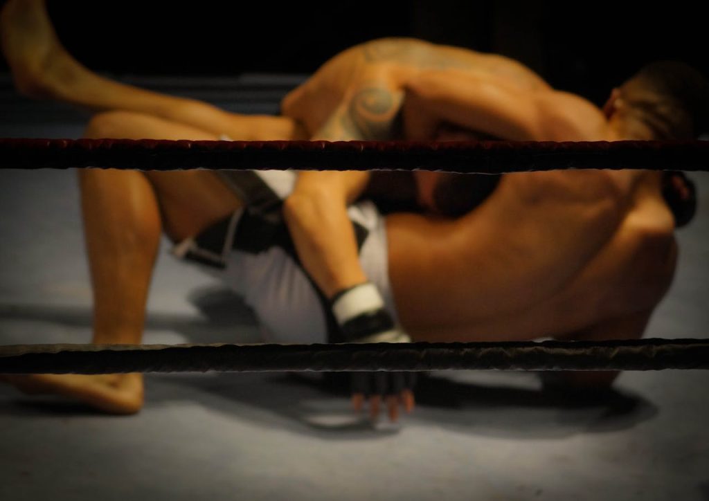 people-men-fight-challenge-650 Two athletes engaged in a dynamic wrestling match within the ring.